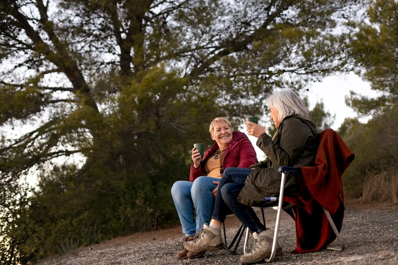 Zwei befreundete Seniorinnen genießen gemeinsam eine Wanderung in der Natur.